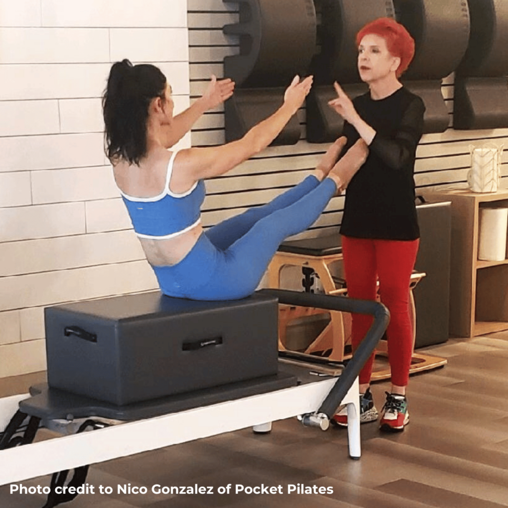 Patricia coaching a student teaser position on a Pilates reformer